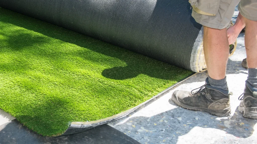 Professional installation of a OneGrass synthetic turf roll for a residential landscaping project