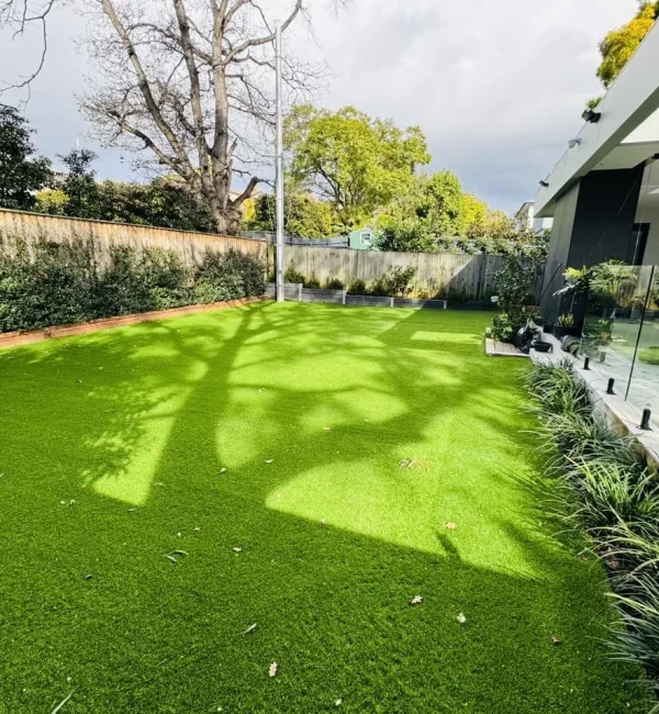 Lush OneGrass synthetic turf provides a clean, green play surface for a modern residential backyard
