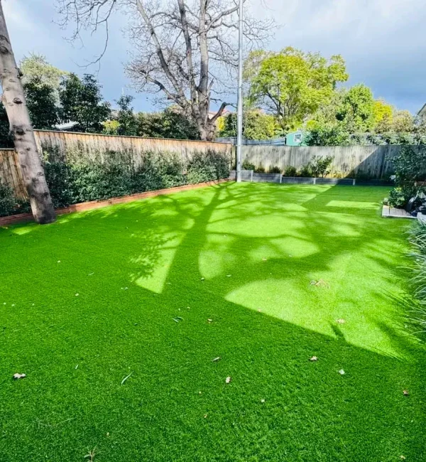 Lush OneGrass synthetic turf provides a clean, green play surface for a modern backyard