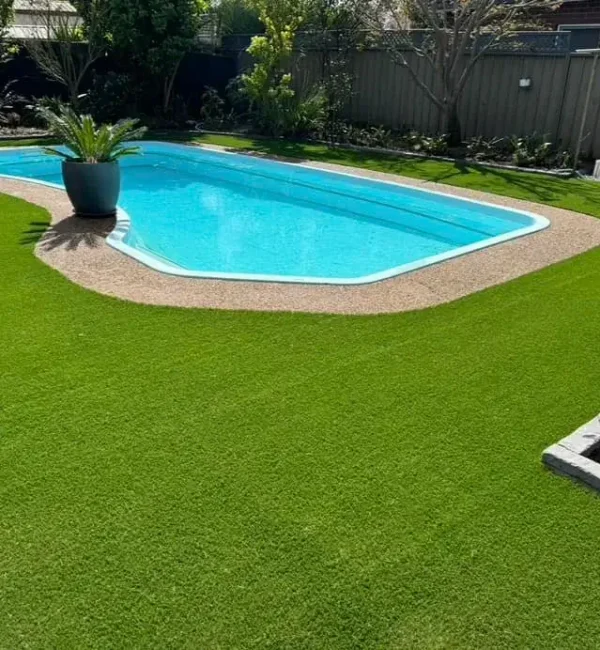 OneGrass premium artificial grass provides a seamless, low-maintenance lawn for this modern backyard swimming pool area