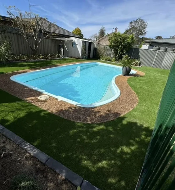 OneGrass artificial grass provides a seamless, low-maintenance lawn for this modern backyard swimming pool area