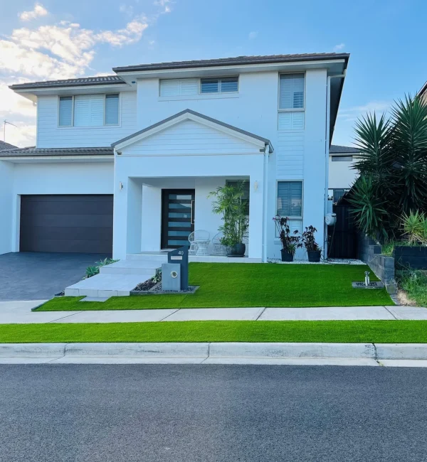 Lush OneGrass synthetic turf provides a neat, low-maintenance front lawn and nature strip for a modern white home