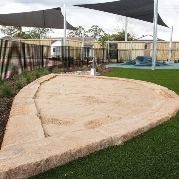 OneGrass synthetic turf installed in a modern childcare outdoor play area with shade sails
