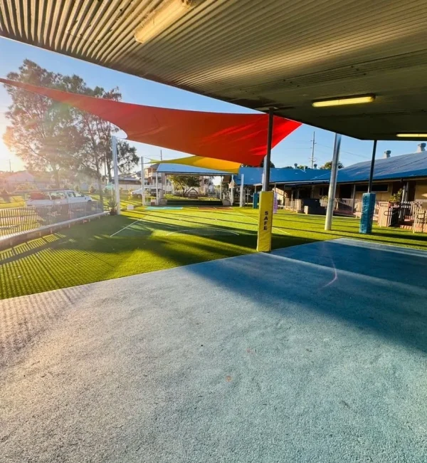 OneGrass multi-sport synthetic turf installed at a school playground featuring bright colour shade sails