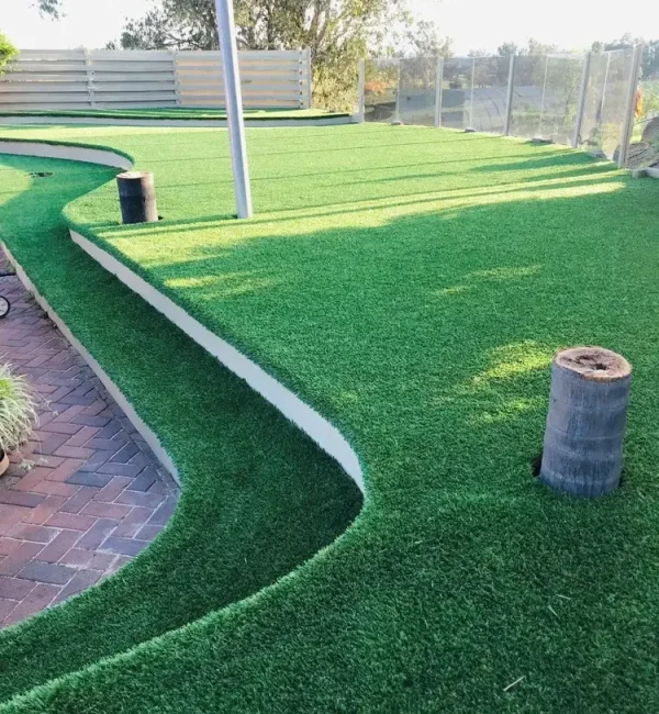 Tiered backyard transformation featuring OneGrass synthetic turf installed on curved, multi-level garden terraces