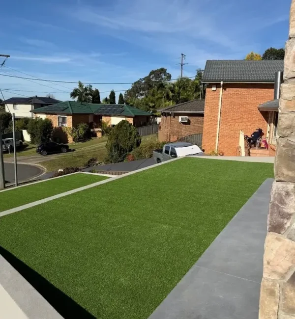 OneGrass synthetic turf provides a pristine, level front lawn for a modern home on a sloped suburban block