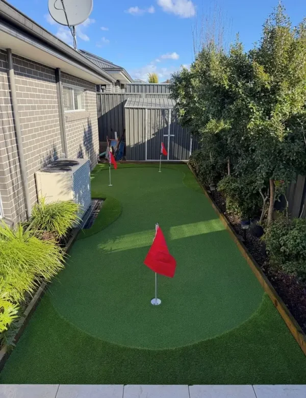 OneGrass synthetic turf with multiple golf holes and flags was professionally installed in a residential backyard
