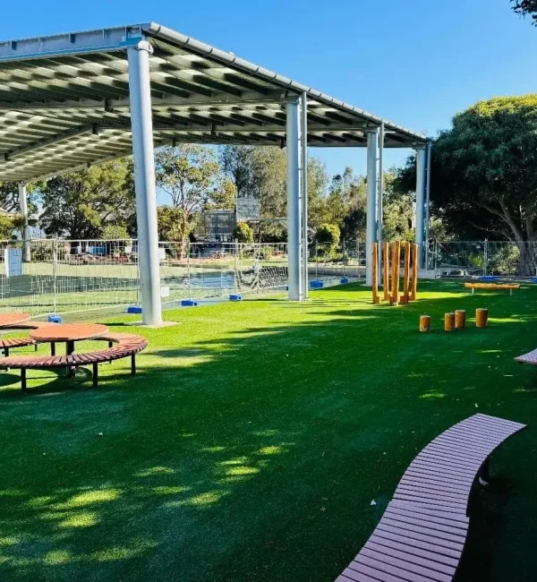 OneGrass synthetic grass creates a green, versatile surface for an undercover school play area with timber seating