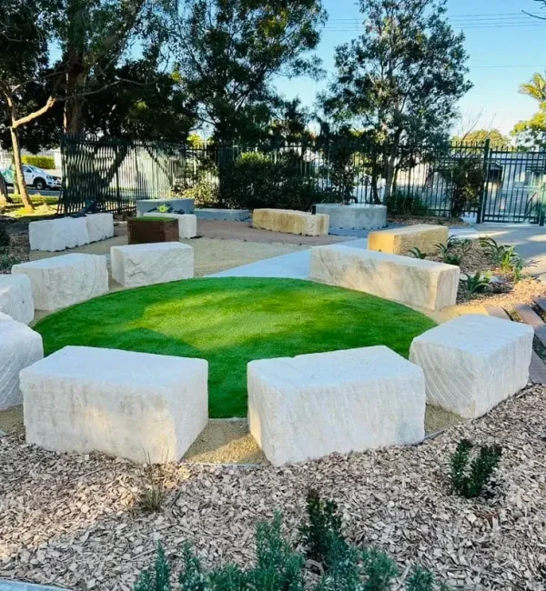 OneGrass synthetic turf provides a soft, circular lawn centrepiece surrounded by large sandstone block seating